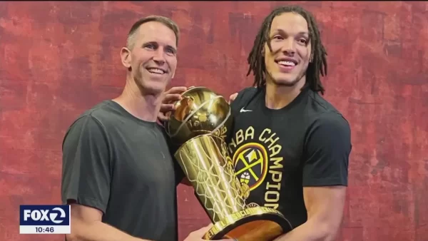 Aaron Gordon and Coach Kennedy both holding the Championship Trophy after the Denver Nuggets won the NBA Finals against the Miami Heat.