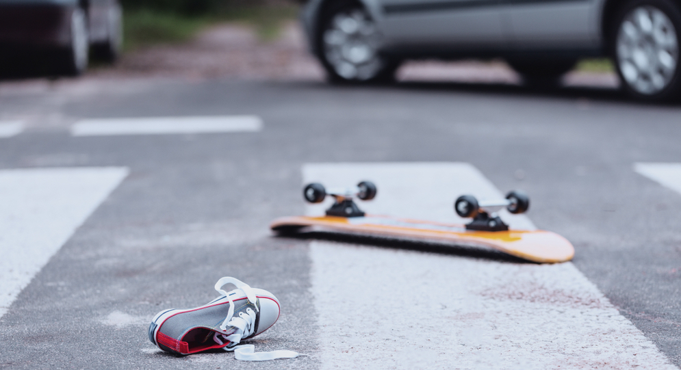 Teenager's shoe and skateboard lying on a pedestrian crossing after traffic accident